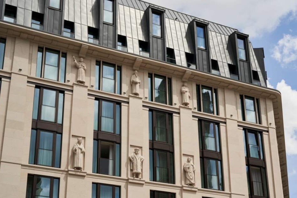 Mannshohe Sandsteinfiguren schmücken die Fassade des neuen Gebäudes.