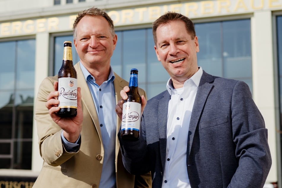 Marketingchef Marco Domogalski (r.) und Brauereichef Olaf Plaumann stoßen mit neu designten Flaschen auf den neuen Spot an.