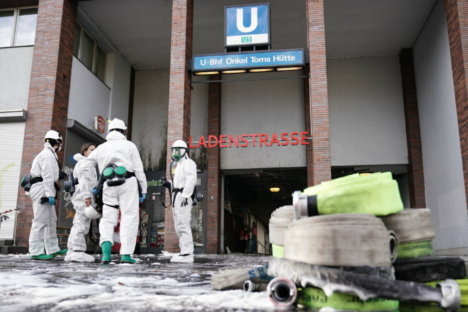 Ermittler der Polizei stehen nach einem Großbrand in dem Bahnhof vor der U-Bahn-Station Onkel Toms Hütte in Zehlendorf.