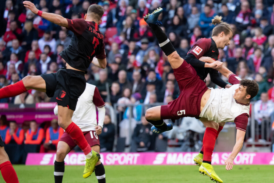 Florian Niederlechner (l.) von Augsburg und Benjamin Pavard vom FC Bayern in Aktion.