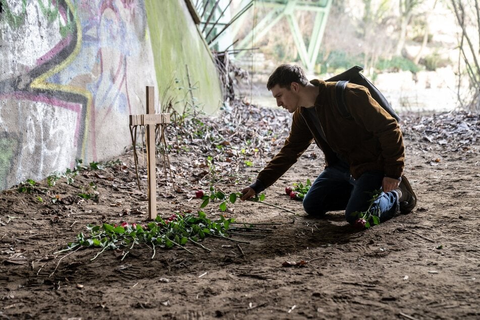 Dennis legt Rosen an Merles Fundort ab.