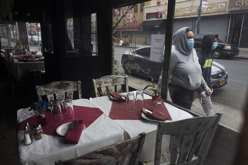 Die Tische werden im geschlossenen Restaurant San Gennaro im New Yorker Stadtteil Bronx während der Coronavirus-Pandemie gedeckt. In der Millionenmetropole New York gelten ab dem heutigen Montag an lockerere Regeln im Umgang mit der Corona-Pandemie.