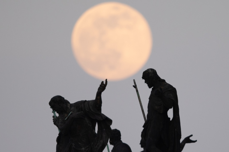 Der Mond geht als sogenannter Supermond auf, im Vordergrund sind die Mattielli-Statuen auf der Katholischen Hofkirche in Dresden zu sehen.