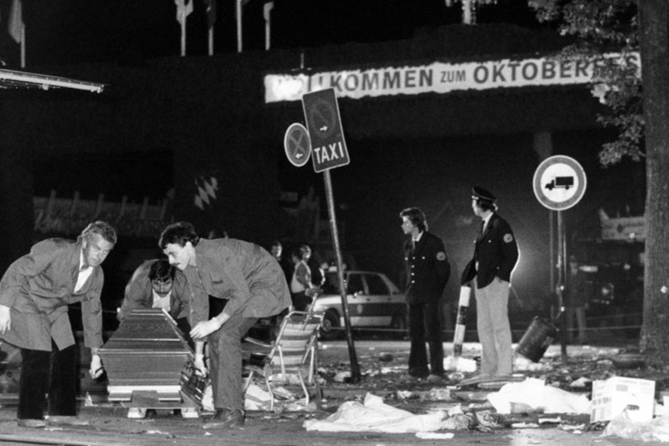 Ein Sarg wird vom verwüsteten Tatort weggetragen. Bei dem schlimmsten rechtsterroristischen Anschlag am 26. September 1980 starben 13 Menschen, darunter der Attentäter, mehr als 200 wurden verletzt. (Archiv)