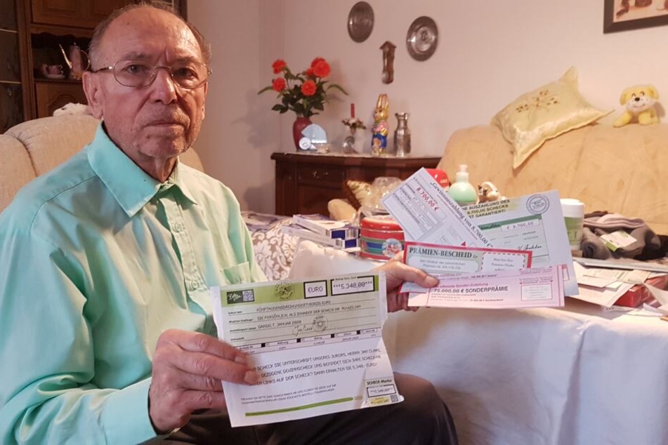 Dieter S. (83) mit der Vielzahl an Gewinnversprechen, die er per Post zugeschickt bekommen hat.