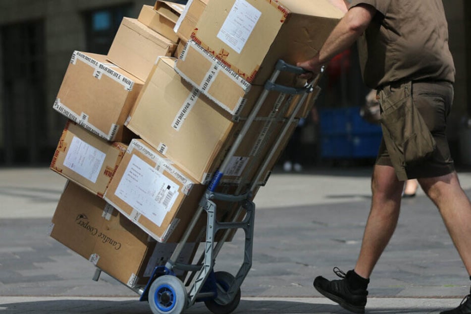 Ein Paketbote liefert Pakete aus. (Symbolbild)