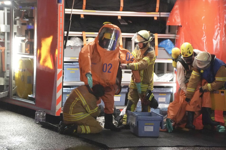 Mehrere Feuerwehrleute zogen sich eine spezielle Sicherheitskleidung an.