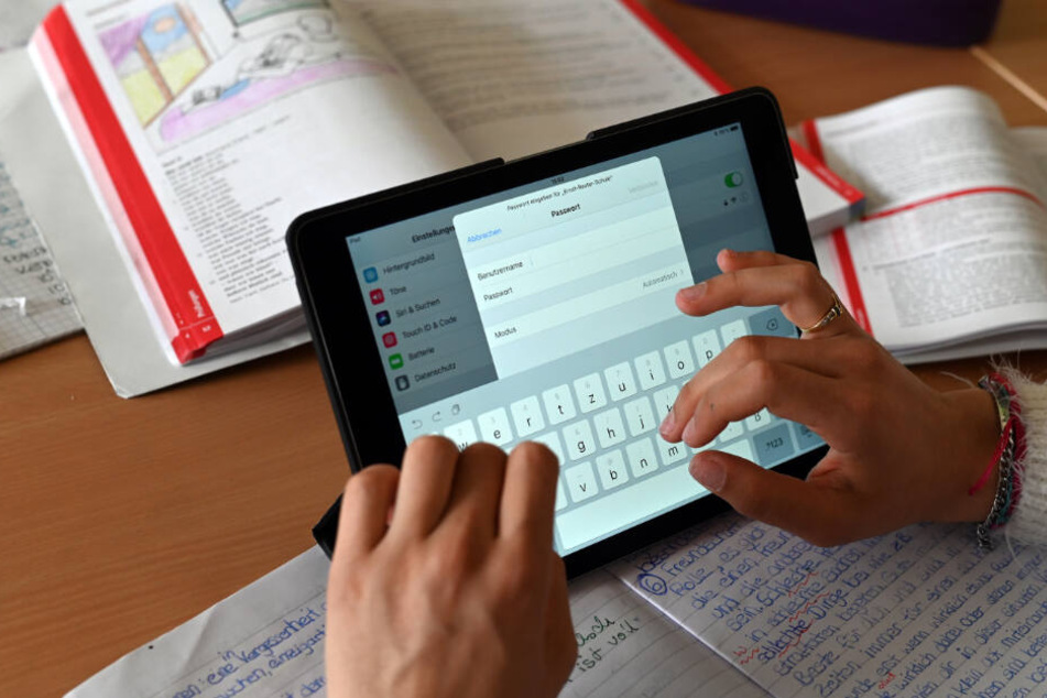 Realschüler einer zehnten Klasse arbeiten in einer Unterrichtsstunde mit Tablets.