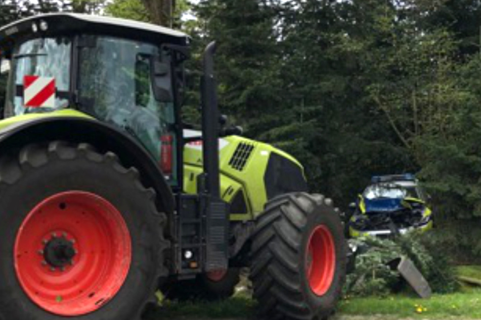 Der Traktor schob den Streifenwagen ins Gebüsch.