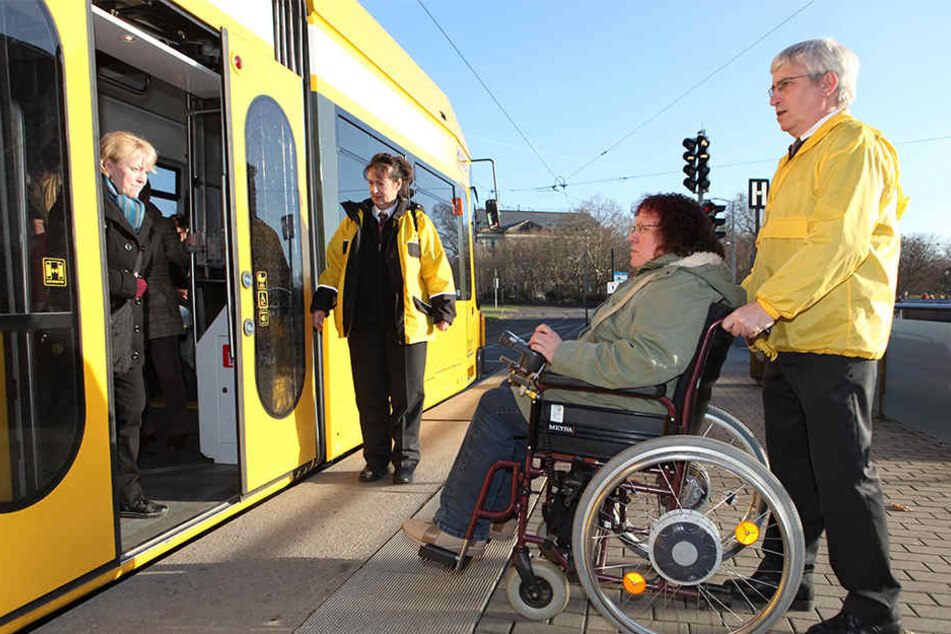 Ein Bürgerarbeiter hilft in Dresden einer Rollstuhlfahrerin in die Bahn. Doch nicht überall wird Behinderten so vorbildlich begegnet.