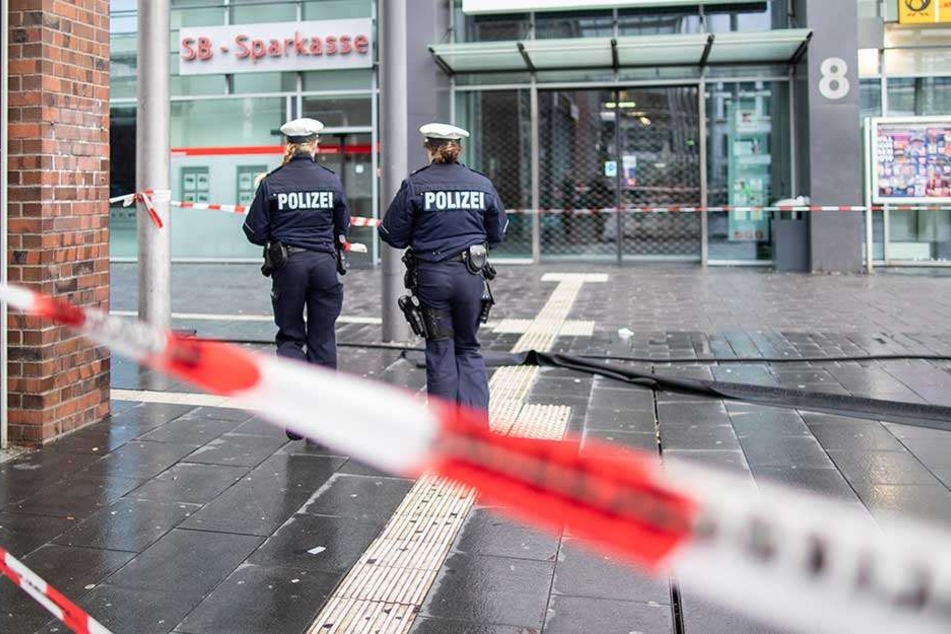 Polizisten laufen hinter Absperrband auf dem Berliner Platz.