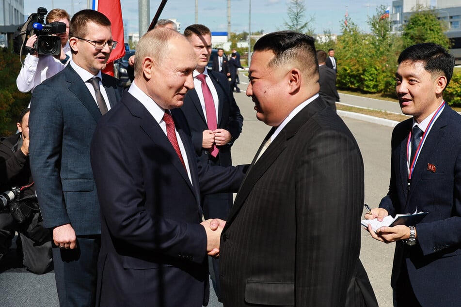 Russia's President Vladimir Putin (center l.) shakes hands with North Korea's leader Kim Jong Un (center r.) during their meeting on September 13, 2023, ahead of alleged weapons deal talks.