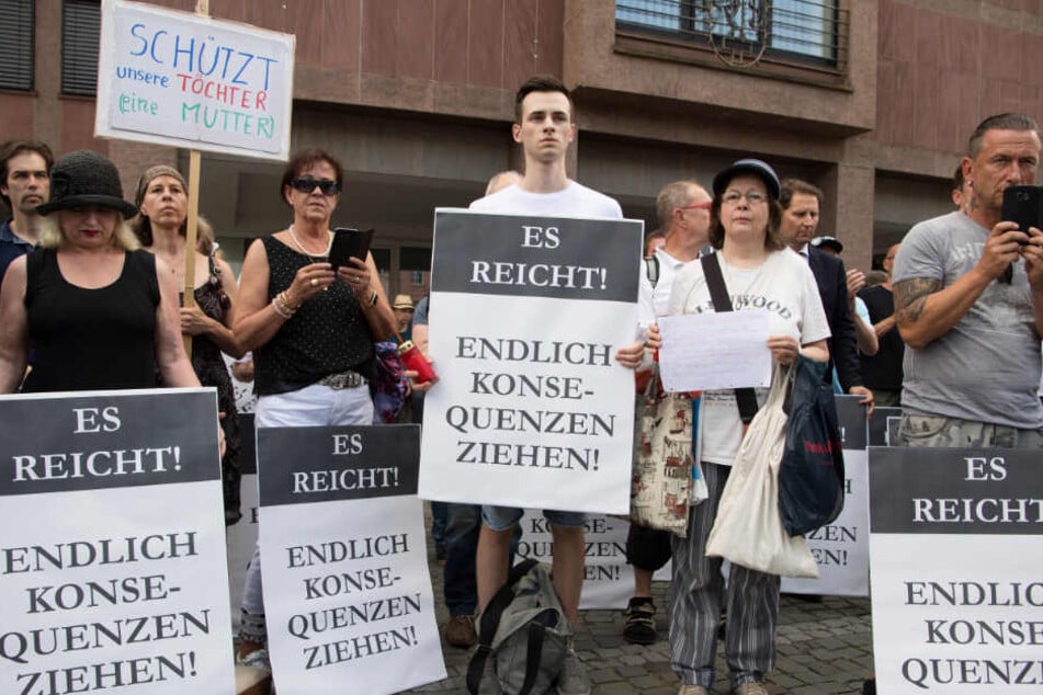 Teilnehmer an einer von der AfD organisierten Mahnwache für die getötete Susanna halten Schilder in die Höhe.