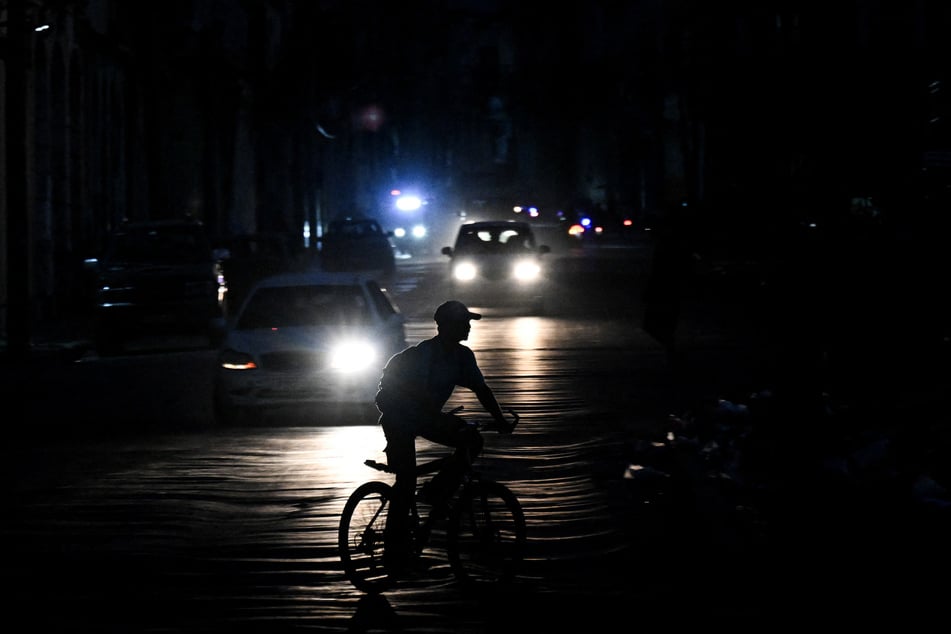 A man rides his bicycle down a street during a blackout in Havana, Cuba, on August 1, 2026.