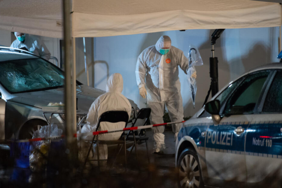 Ermittlungsbeamte stehen an dem Auto des Tatverdächtigen.