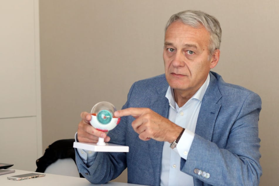 Der Augenchirurg Francis Ferrari zeigt anhand eines Augenmodells, wie er seinen Kunden auf Wunsch die Augenfarbe ändert. 