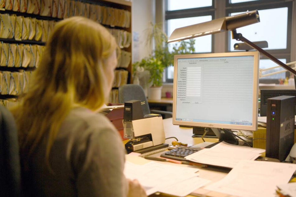 Eine Behördenmitarbeiterin verwaltet Daten an einem Computer. (Archivbild)