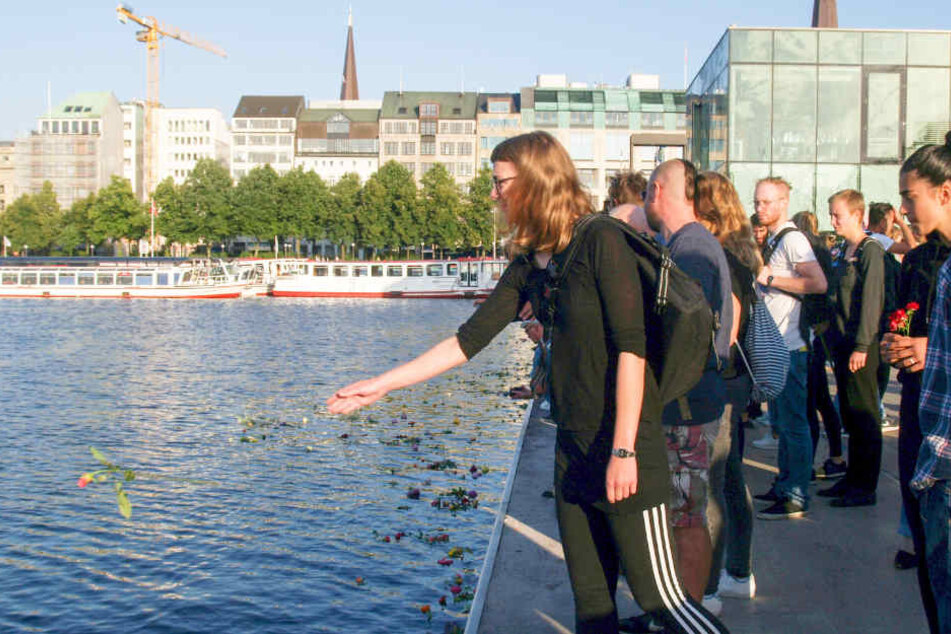 Die Demonstranten warfen am Jungfernstieg symbolisch Blumen in die Alster, um den Toten im Mittelmeer zu gedenken.