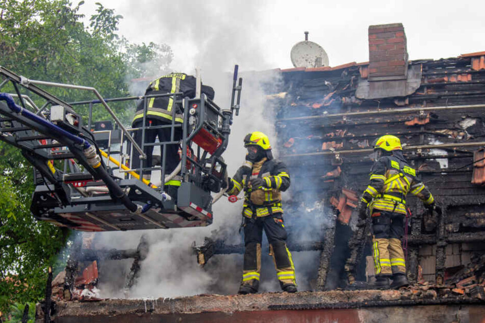 Mit Atemschutzmasken bekämpft die Feuerwehr die Glutnester.