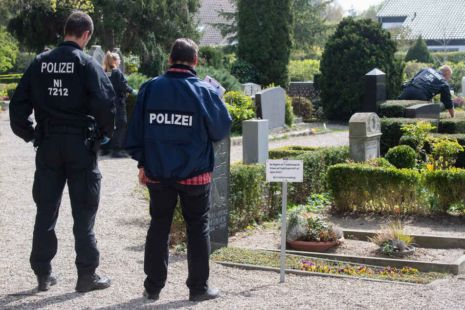 Polizisten suchen nach Spuren auf dem Friedhof im Stadtteil Kirchrode.