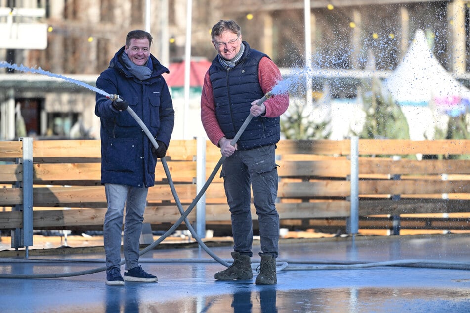 Holger Zastrow (r.) und Mattheo Böhme sprühen in Vorfreude auf die Eröffnung eine letzte Wasserschicht zum Gefrieren auf die Eisfläche.
