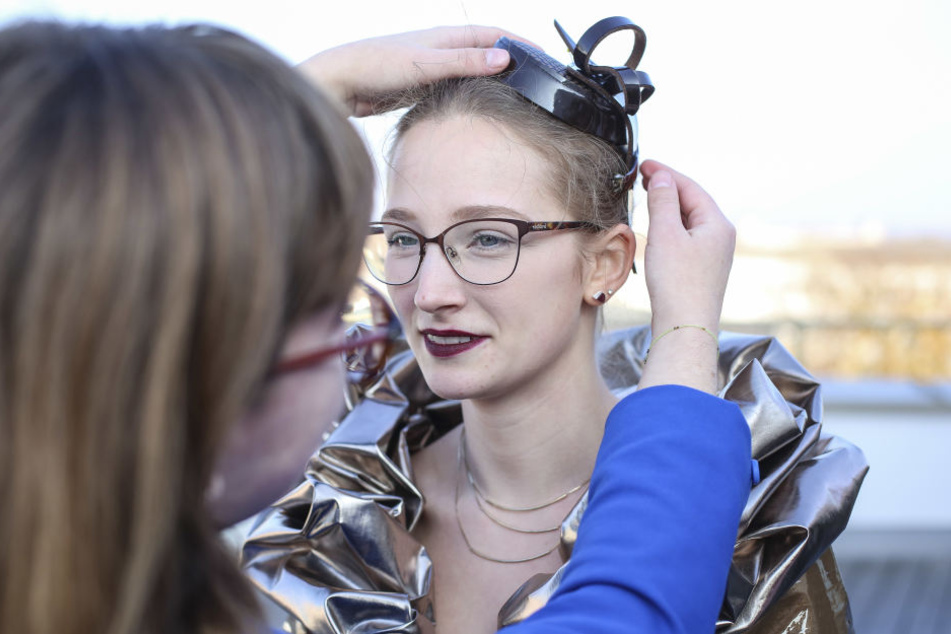 Design-Studentin Nadine Riemer (19, l.) steckt Schoko-Girl Michelle ein Hütchen ins Haar.