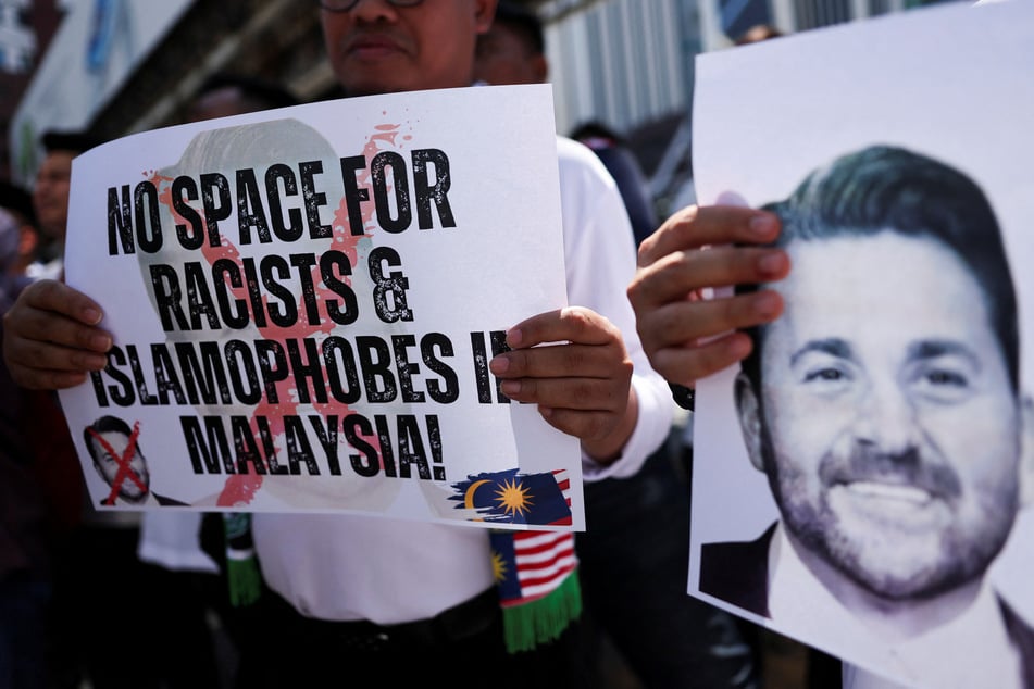 A protester holds a sign reading "No space for racists & Islamophobes in Malaysia" during a rally outside the US Embassy in Kuala Lumpur.
