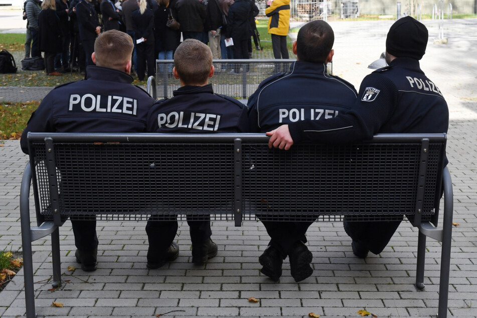 Polizeischüler sitzen vor der Polizeiakademie auf einer Parkbank. (Symbolfoto)