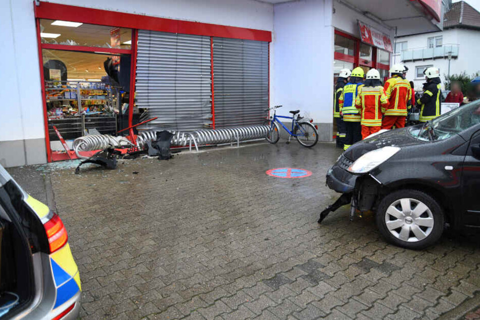 Das Wrack des Autos (rechts) vor der zerstörten Glasscheibe.
