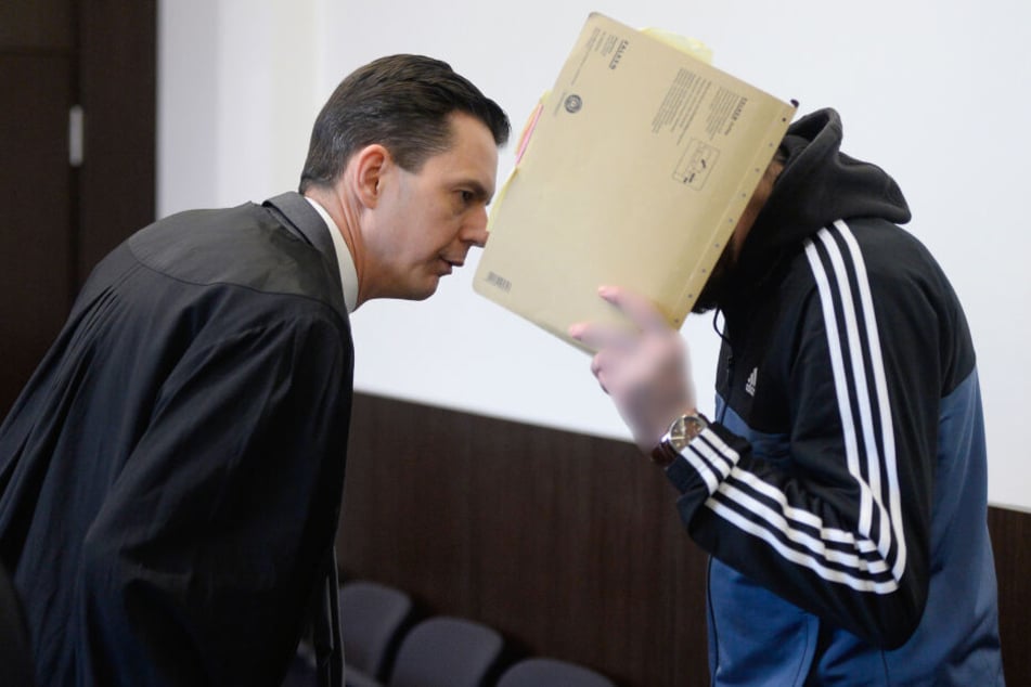 Der Angeklagte (r) spricht vor dem Prozessauftakt mit seinem Rechtsanwalt.