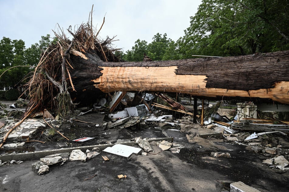 A large tree is uprooted outside of a home near Camp Mystic, the site of where at least 20 girls went missing after flash flooding in Hunt, Texas, on Saturday.