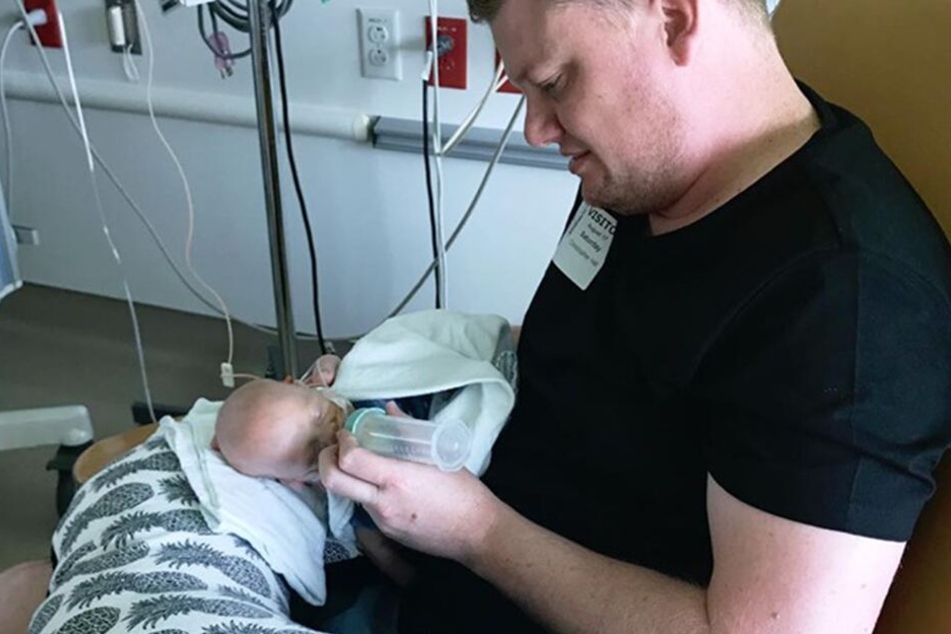 Der stolze Papa Chris Hill füttert seinen Sohn Finn mit einem Fläschchen.