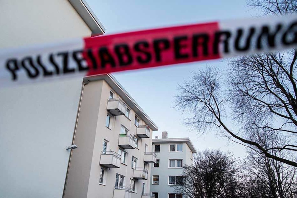 Ein Absperrband der Polizei hängt vor Mehrfamilienhäusern in Essen. Hier war in einer Wohnung die Frau getötet und eine weitere schwer verletzt worden.
