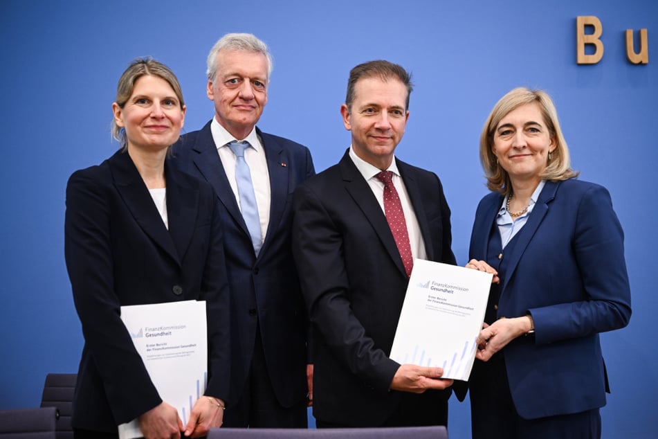 V.l.n.r.: Die Kommissionsvorsitzenden Leonie Sundmacher, Ferdinand M. Gerlach, Wolfgang Greiner zusammen mit Bundesgesundheitsministerin Nina Warken bei der Vorstellung des Reformberichts.