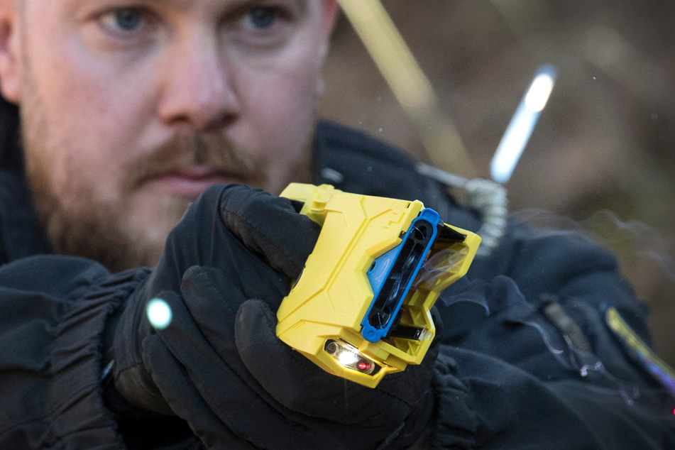 Ein Polizist feuert einen Taser auf sein Ziel ab (Archivbild).