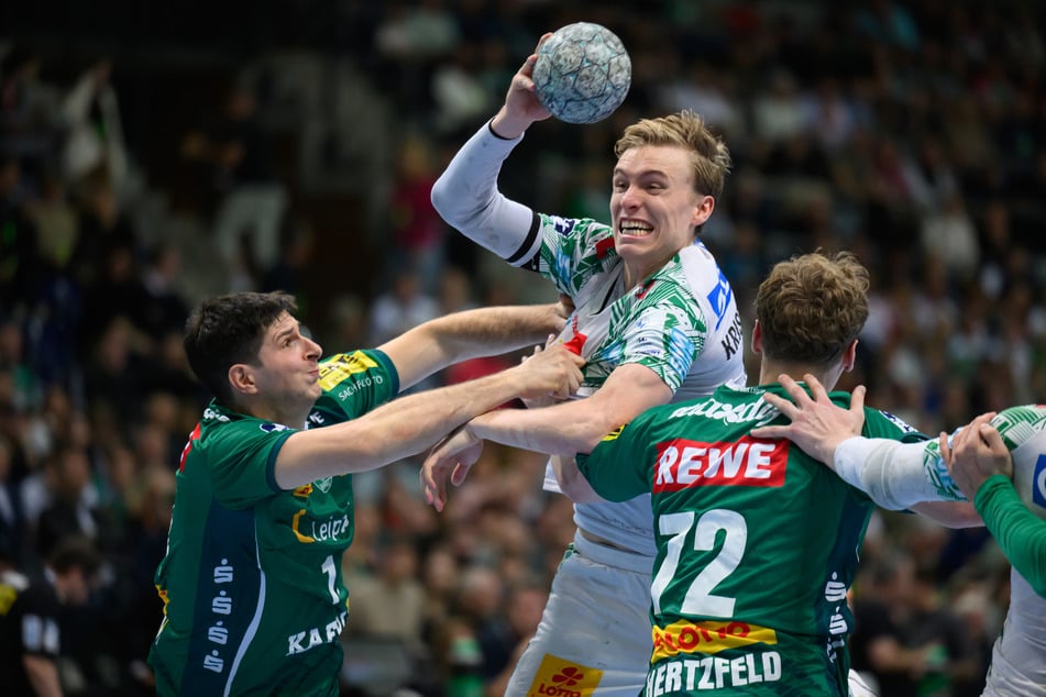 Magdeburgs Gisli Kristjánsson (M.) setzt sich gegen Leipzigs Spieler Marko Mamić (l.) und Tim Maximilian Hertzfeld (r.) durch.