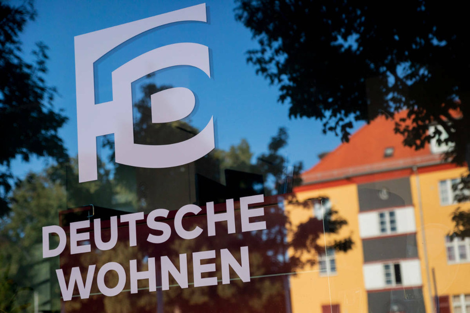 Das Logo von Deutsche Wohnen ist auf der Fensterscheibe eines Vermietungsteams in der Hufeisensiedlung in Berlin-Neukölln zu sehen. Deutschlands größter Wohnungskonzern Vonovia will den Berliner Marktführer unbedingt übernehmen.