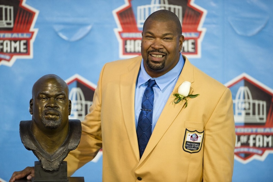 Former offensive lineman Larry Allen of the Dallas Cowboys poses with his Hall of Fame bust during the NFL Class of 2013 Enshrinement Ceremony.