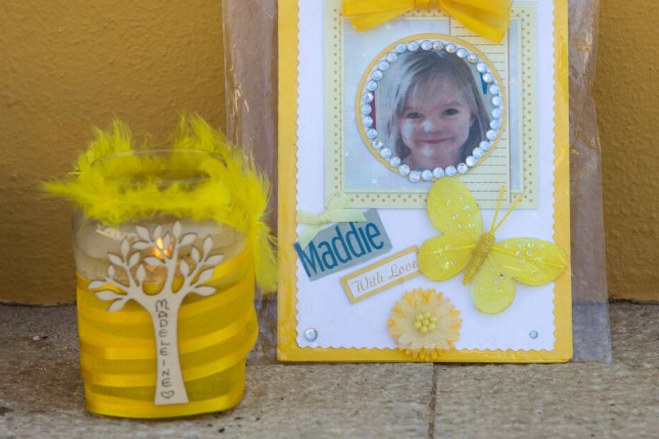 Eine Kerze und ein Porträtfoto von Madeleine McCann stehen in Praia da Luz (Portugal).