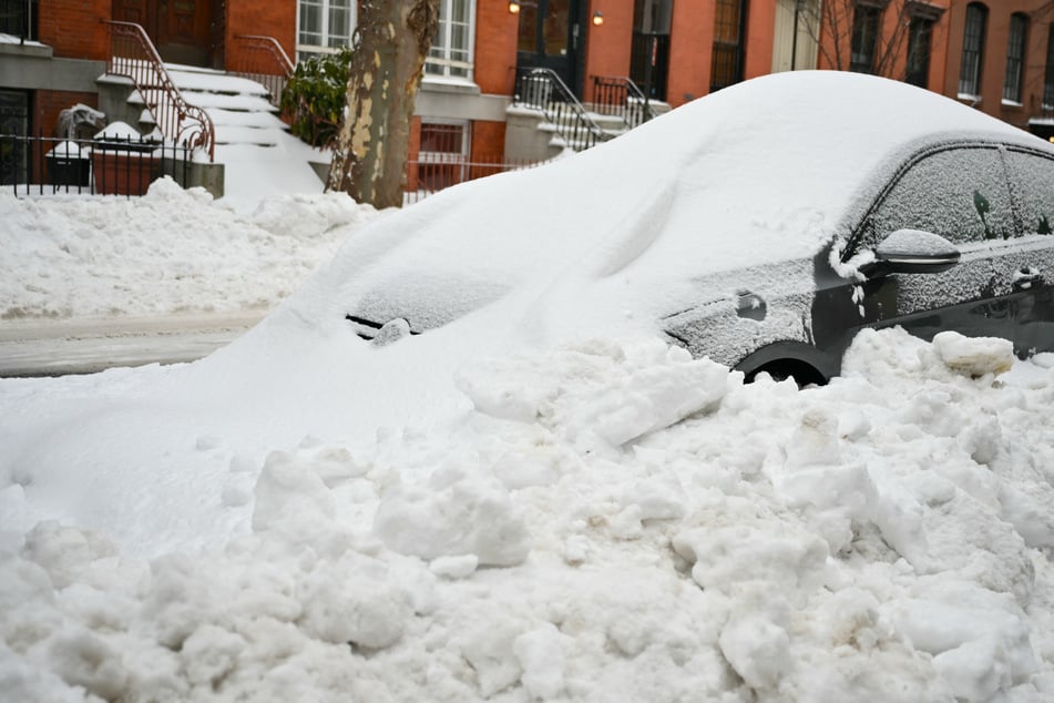 A car is plowed in with snow a day after a winter storm swept through the region in the Brooklyn borough of New York City on January 26, 2026.