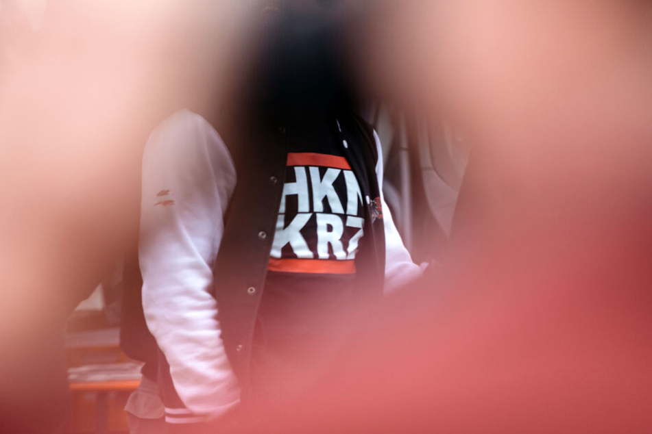 Ein Mann trägt am auf dem Gelände eines Rechtsrock-Konzertes in ein T-Shirt mit der kryptischen Aufschrift "HKNKRZ", das für das Hakenkreuz-Symbol stehen soll. (Archivbild)