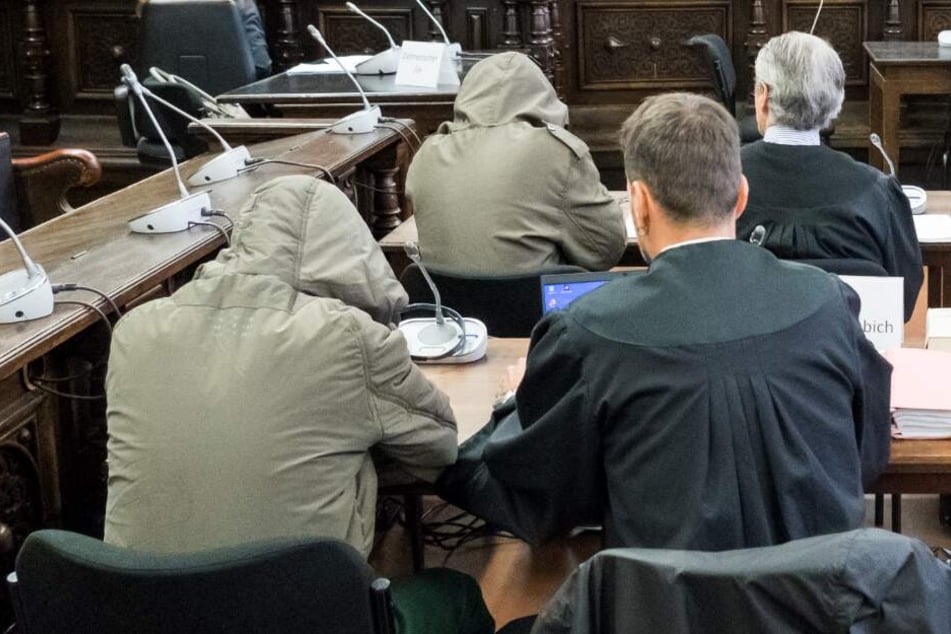Terror-Verdacht: Drei Angeklagte sitzen im Landgericht im Saal neben ihren Anwälten.