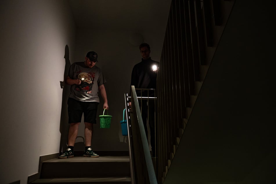 Im finsteren Treppenhaus sind die Mieter auf Handys und Taschenlampen angewiesen.