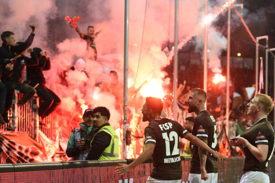 Die St.-Pauli-Spieler jubeln nach einem Tor vor den Fans, die Pyro zündeten.