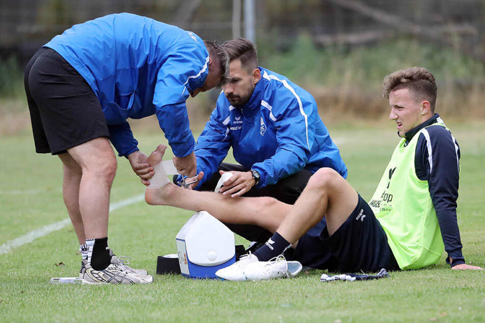 Die ersten Wehwechen gab es auch gleich. Die Physiotherapeuten Olaf Renn und Florian Braband kümmern sich um den am Fuß lädierten Tim Campulka (r.). Er muss die kommenden Tage pausieren.