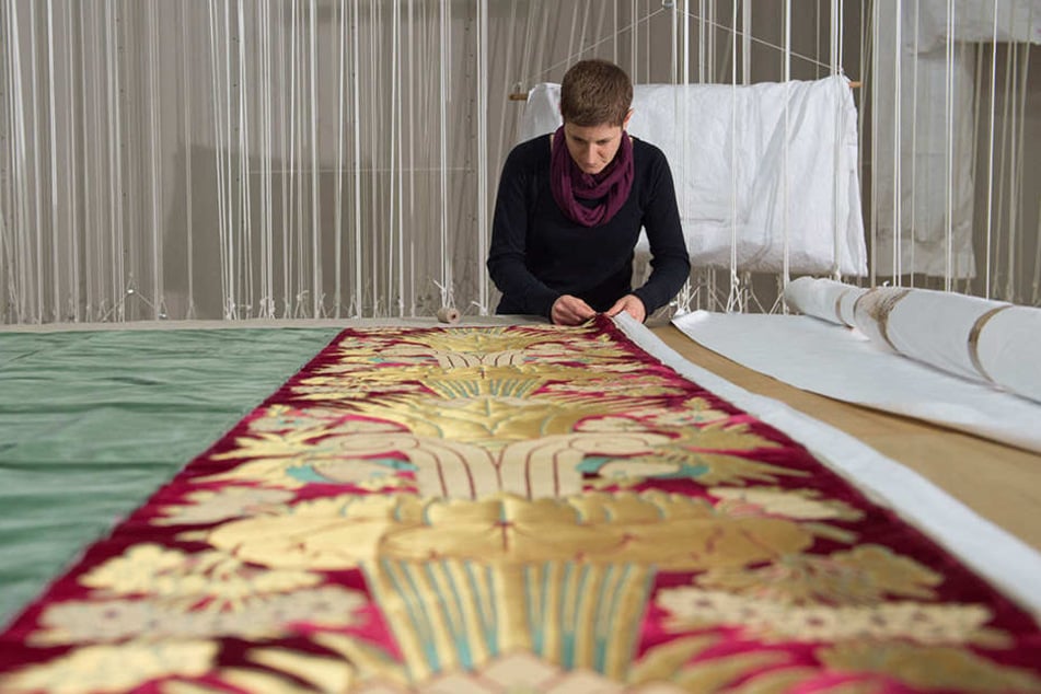 Tapeziererin Julia Modest arbeitet an einem edlen Wandbehang aus Samt.