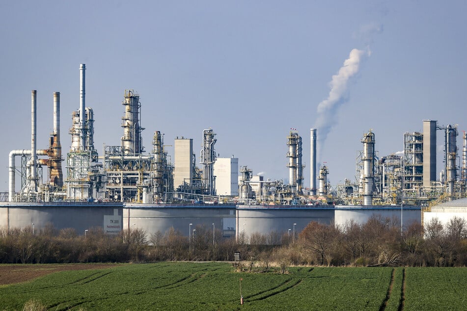 Hinter einem Tanklager ragen die Anlagen der TotalEnergies-Raffinerie Leuna in die Höhe. Hier wird aus Rohöl Benzin, Diesel und Flugzeugsprit gemacht.