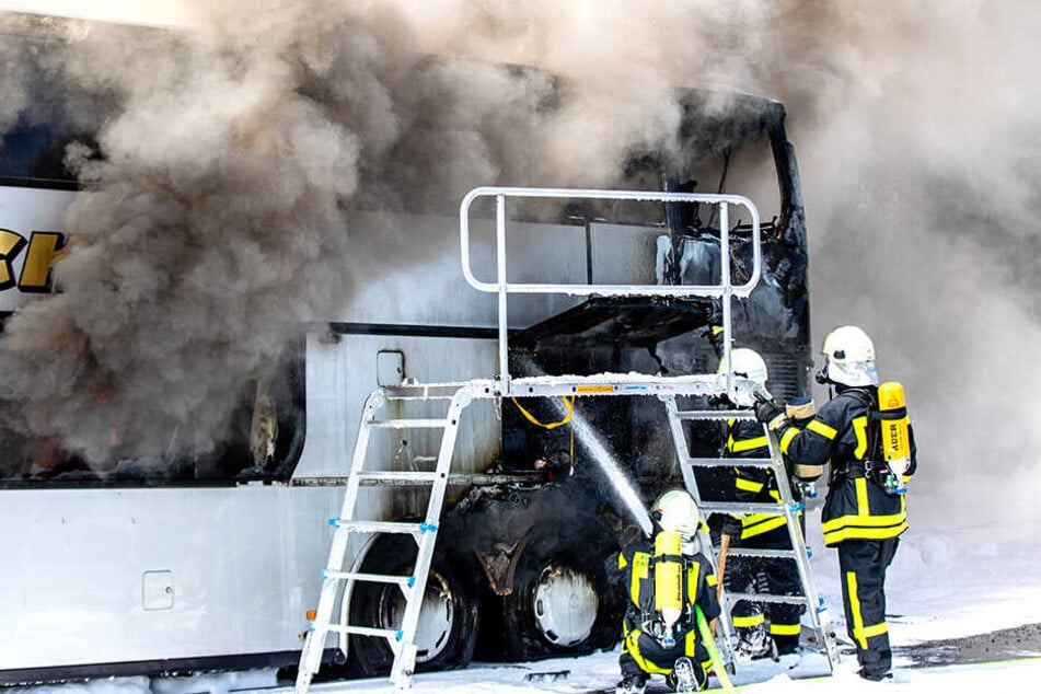 Feuerwehrleute löschen die Flammen.