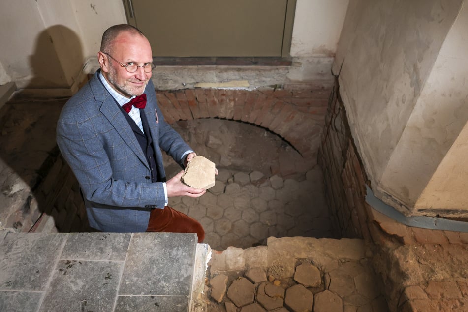 Der Direktor der Stiftung Luthergedenkstätten Thomas T. Müller zeigt den freigelegten Fußboden.