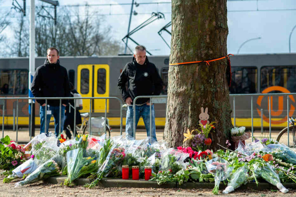 Passanten stehen vor dem provisorischen Denkmal in der Nähe des Ortes, an dem drei Menschen von einem Schützen in einer Straßenbahn getötet wurden.